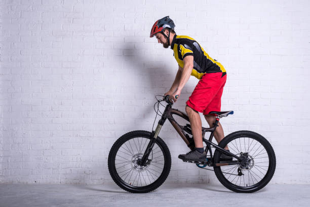 istock Cyclist on a full mountain suspension against a brick wall. 1150669655