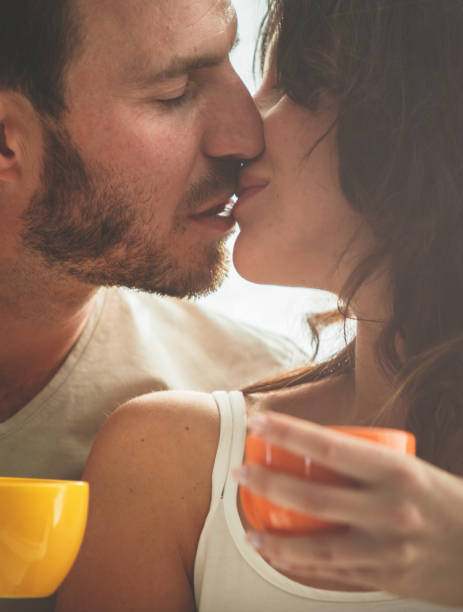 istock Couple kisses while drinking coffee together 1150670774