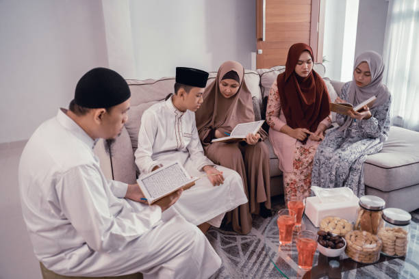 muslim family reading quran together in livingroom portrait of muslim family reading quran together in livingroom father allah stock pictures, royalty-free photos & images