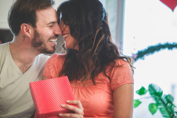 istock Cheerful couple cuddling together, sharing gifts 1150673834
