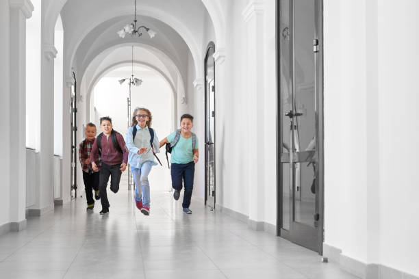 istock Happy classmates running in school after lessons. 1150675640