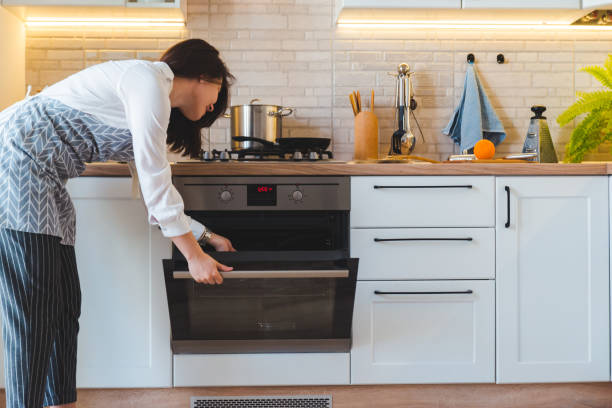 jeune jolie femme four ouvert pour cuisiner. concept de cuisine domestique - oven photos et images de collection