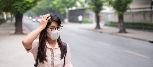 istock Woman Wearing Pollution Mask Standing By Road 1150676106
