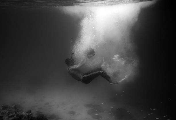 Diver plummet into black ocean with sunlight bubble,black and white
