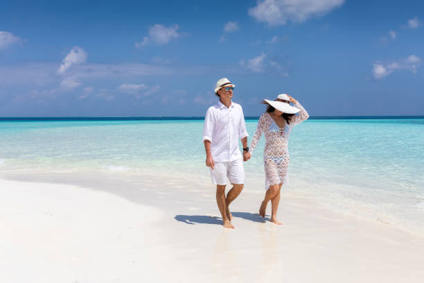istock Happy couple walks down a tropical beach 1150677067