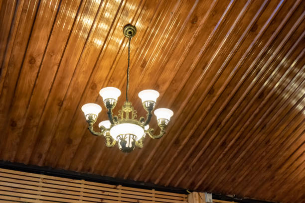Retro chandelier lamp illuminate hanging on ceiling in wooden room