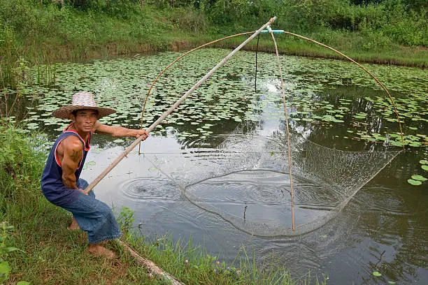 Fisherman with fishing-net, Asia, in Thailand at a small lake