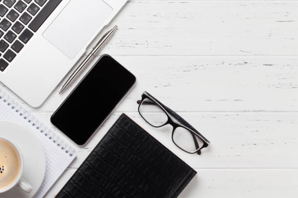 istock Office workplace table with smartphone, glasses and supplies 1150682621