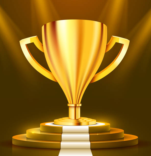 istock Realistic Golden Trophy on round podium with white carpet illuminated with spotlight. Award ceremony concept. Stage backdrop. 1150684005