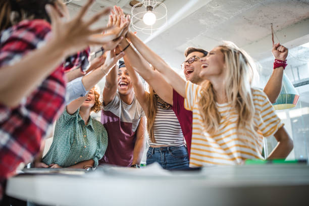 istock Below view of happy university students gathering hands in unity. 1150684958