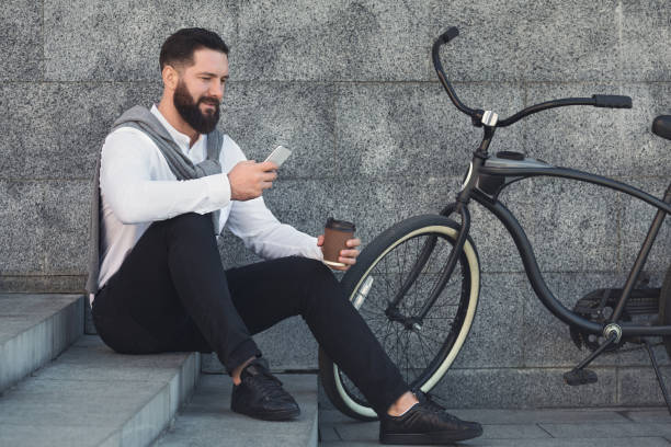 istock Businessman on coffee break, sitting on stairs and using smartphone 1150685598