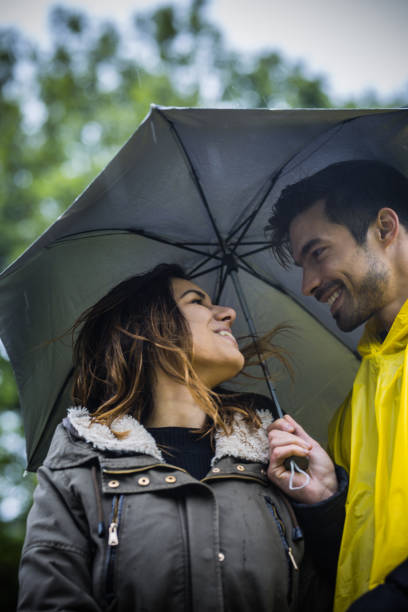 istock Couple under umbrella walking during rainy spring day 1150685617