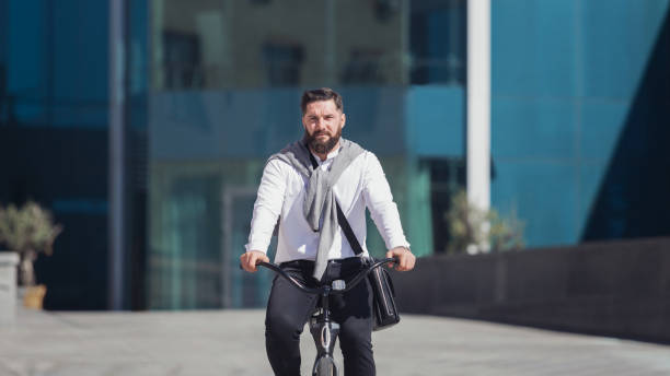 istock Active serious bearded businessman riding his bicycle 1150685627