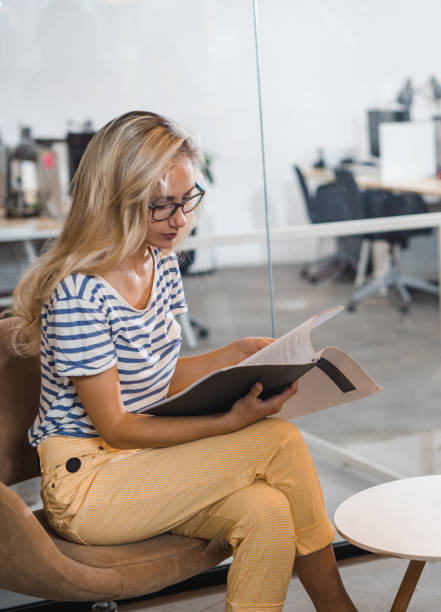 istock Female college student reading a book while preparing for her exams. 1150685874