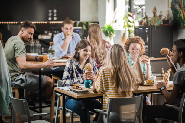istock Group of happy students talking while having lunch break at cafeteria. 1150685921