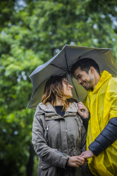 istock Couple under umbrella walking during rainy spring day 1150685970