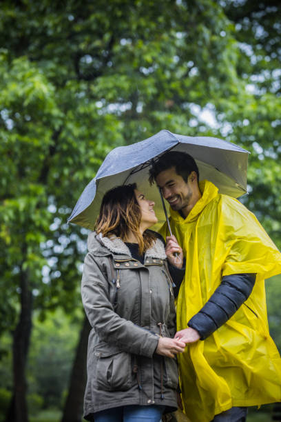 istock Couple under umbrella walking during rainy spring day 1150686080
