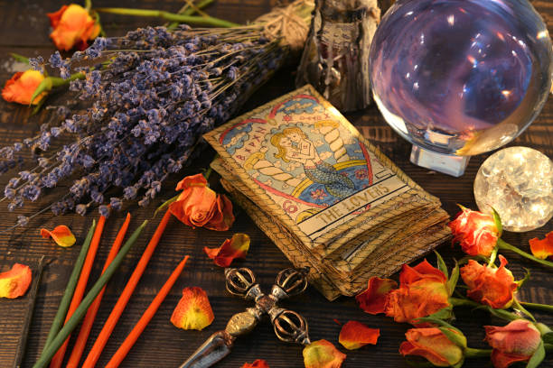 Tarot cards with magic crystal ball, candles and lavender flowers. Tarot cards with magic crystal ball, candles and lavender flowers. Wicca, esoteric, divination and occult background with vintage magic objects for mystic rituals crystal altar stock pictures, royalty-free photos & images