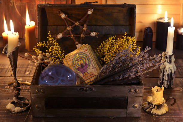 Witch box with healing herbs, crystal ball, tarot cards and burning candles. stock photo