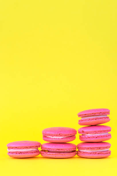istock Pink macaroons on a yellow background. Concepts of classification and growth 1150689469
