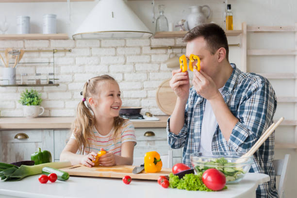 istock Dad and daughter having fun while preparing healthy meal together 1150690784