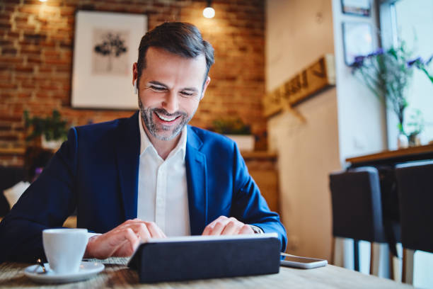 istock Businessman having phonecall through wireless headphones while working on tablet in cafe 1150690895