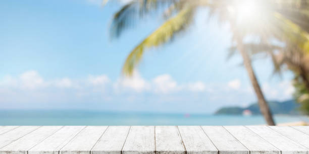 Empty wood table top and blurred summer beach with blue sea and sky banner background. - can used for display or montage your products.