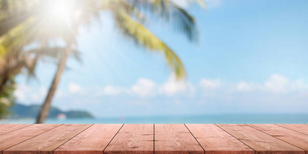istock Empty wood table top and blurred summer beach with blue sea and sky banner background. - can used for display or montage your products. 1150692824