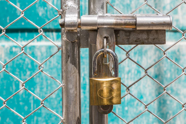 istock metal fence  is unlock with a gold keychain 1150692895