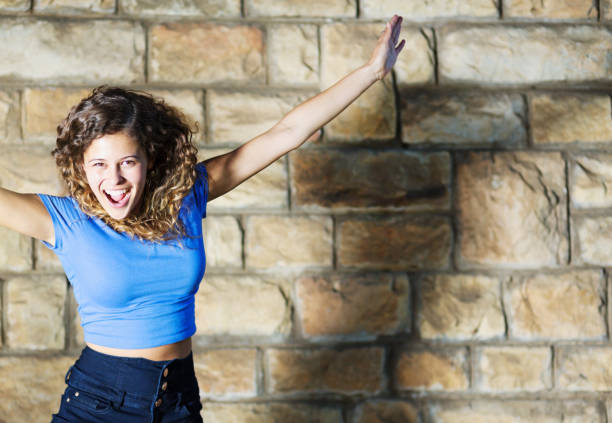 istock Beautiful, curly-haired young brunette jumps for joy 1150693054
