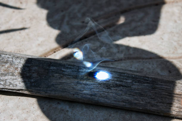 starting a fire with a magnifying glass on a wood.