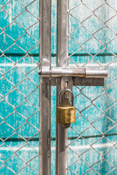 istock metal fence  is unlock with a gold keychain 1150694883
