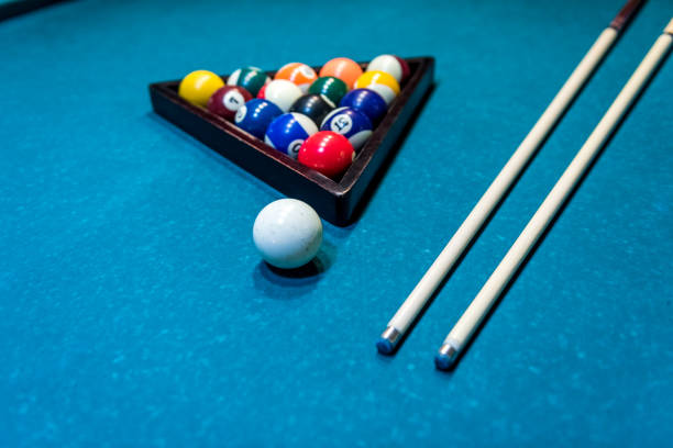istock Billiard balls in triangle with cue on table 1150696050