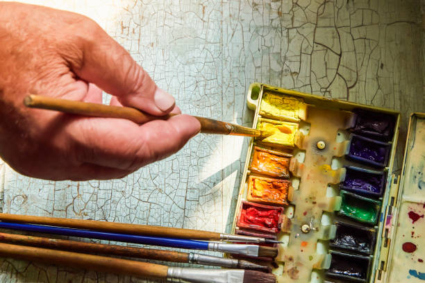 istock artist's tools, professional watercolor paints in a box, artist's brushes and brushes on a bright old table 1150696250