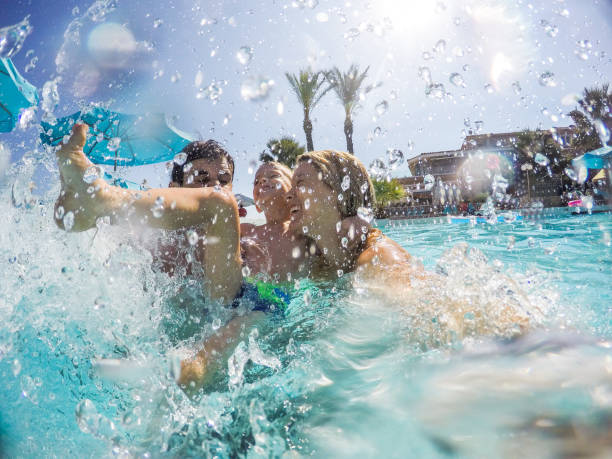 rodzina pluskająca się w basenie - resort swimming pool swimming swimming pool women zdjęcia i obrazy z banku zdjęć