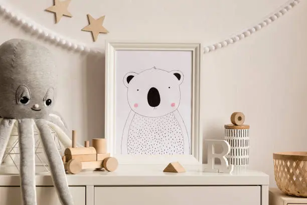 Photo of Stylish scandinavian newborn baby shelf with mock up photo frame, rattan basket, plush octopus, wooden toys. Gray garland and white stars. Modern interior with white walls and children accessories.