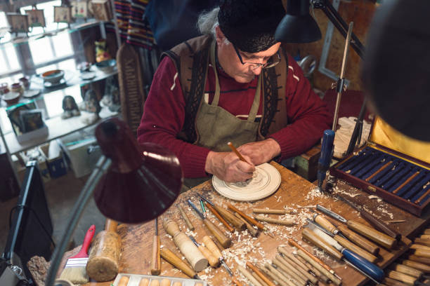 istock Artist crafting wood figurine at his studio 1150700874