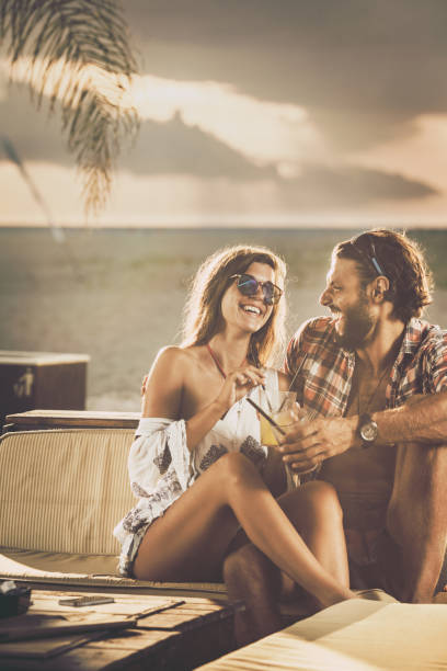 istock Cheerful couple talking while enjoying in beach bar at sunset. 1150702251