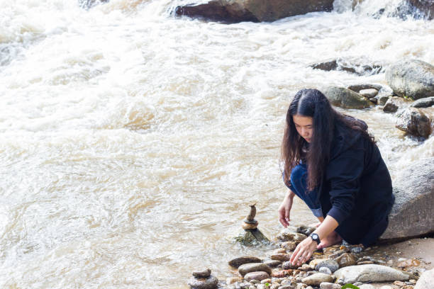 istock Woman Stacking Stones In Sea 1150703869