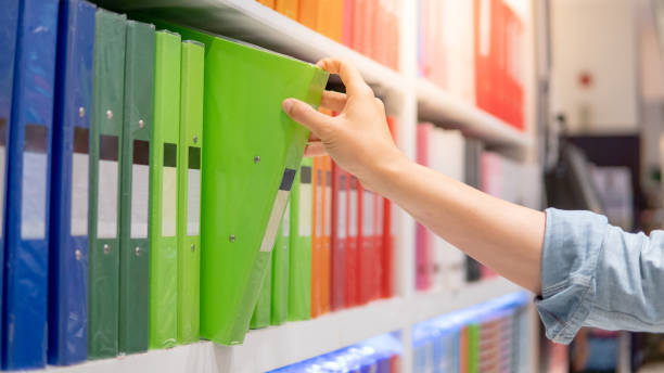 Male hand choosing file folder in stationery shop
