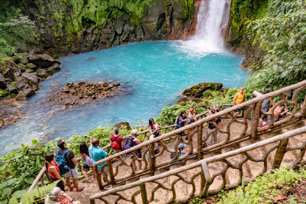 ourists смотреть с платформы живописный водопад в национальном парке вулкана тенорио - челеста стоковые фото и изображения