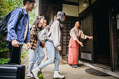Group of young travellers arriving at traditional Japanese ryokan inn
