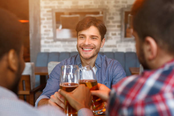 istock Friends drinking beer, celebrating meeting in bar 1150711973