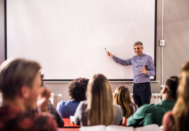 fröhlicher professor, der einen vortrag über visuelle leinwand im klassenzimmer hält. - speech talking teenager student stock-fotos und bilder