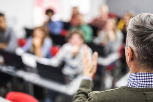 istock Back view of a male teacher giving a lecture on a computer class. 1150714341