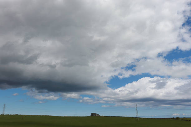 istock Fluffy white clouds against blue sky in rural setting 1150714701