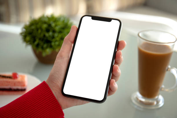 istock female hand holding phone with isolated screen in a cafe 1150714851