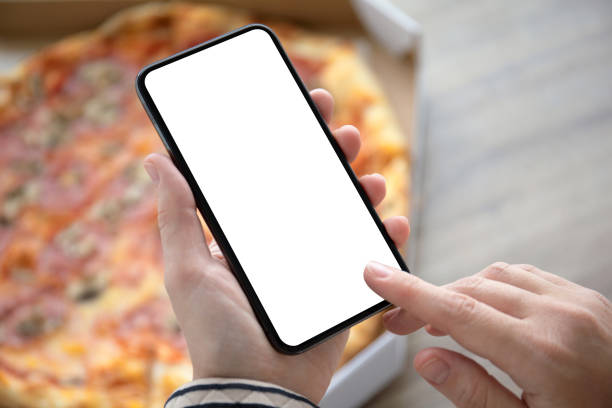 istock female hands holding phone with isolated screen above pizza box 1150715101
