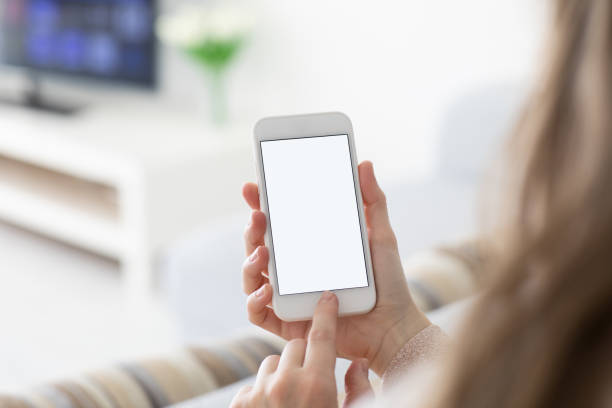 istock Female hands holding phone with isolated screen in  room 1150715720
