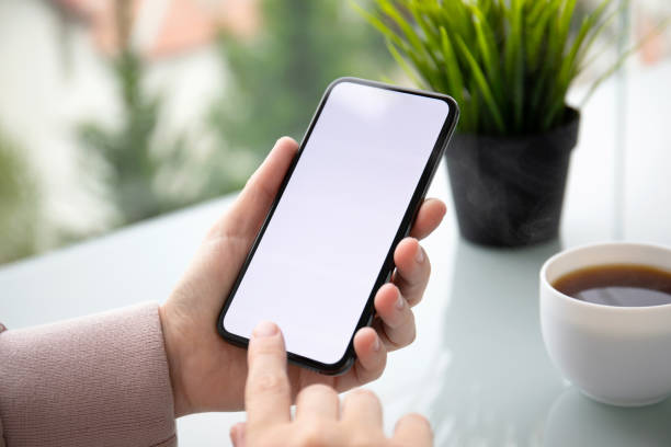 istock female hands holding phone with isolated screen in summer cafe 1150716095